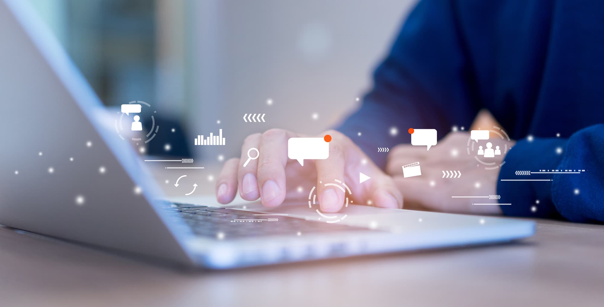 Background image of a man utilizing his computer with multiple types of content icons appearing above: messages, emails, video, infographics, and more.